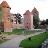 Wieże zamkowe w Chojnicach, Kaszuby, z placem zabaw i zielenią.