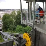 Dzieci na hulajnogach czekają na wjazd kolejką na kamienną górę w Gdyni, podziwiając panoramę miasta.