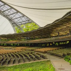 Puste rzędy krzesełek w amfiteatrze w Sopocie czekają na widzów. Nowoczesna, falująca konstrukcja dachu chroni widownię.
