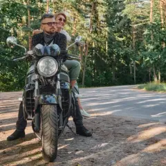 Para z uśmiechem na twarzy, podróżująca motocyklem po malowniczych Kaszubach.