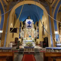 Wnętrze kościoła w Jastarni, bogato zdobiony ołtarz główny z figurami świętych, niebieskie sklepienie z gwiazdami i złote detale tworzą uroczystą atmosferę.