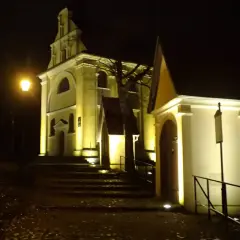 Nocne iluminacje kościołów w Wejherowie. Schody prowadzą do zabytkowych budowli, oświetlonych ciepłym światłem.
