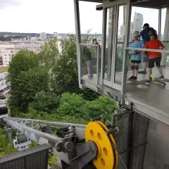 Dzieci na hulajnogach czekają na wjazd kolejką na kamienną górę w Gdyni, podziwiając panoramę miasta.