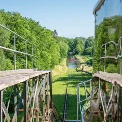Widok z wagonu kolejki linowej na kanał wodny otoczony zielenią. W oddali widać wiatraki. Mątowy wielkie wrażenie.