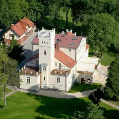 Dworek z wieżą otoczony zielenią, idealne romantyczne miejsce na Kaszubach.