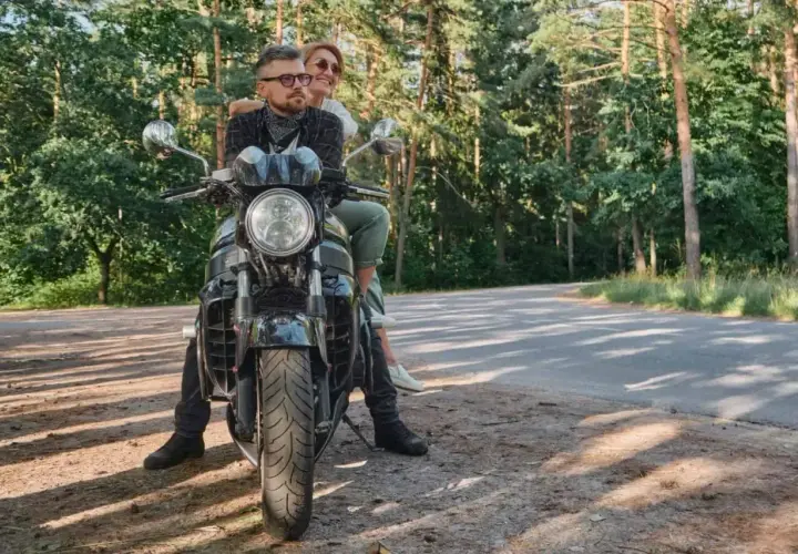 Para z uśmiechem na twarzy, podróżująca motocyklem po malowniczych Kaszubach.