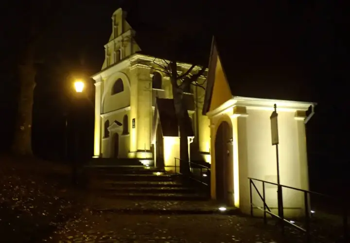 Nocne iluminacje kościołów w Wejherowie. Schody prowadzą do zabytkowych budowli, oświetlonych ciepłym światłem.