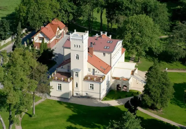 Dworek z wieżą otoczony zielenią, idealne romantyczne miejsce na Kaszubach.