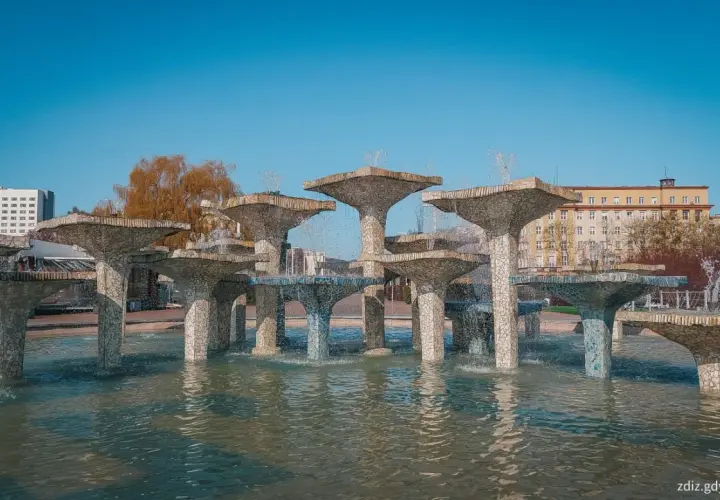 Monumentalna fontanna w Gdyni, z kaskadami wody spływającej po kamiennych, grzybkowatych formach.
