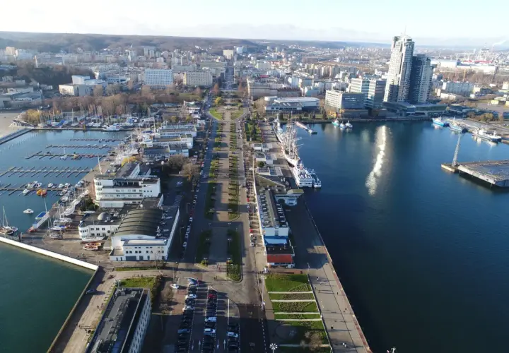 Widok z lotu ptaka na Skwer Kościuszki w Gdyni z mariną, statkami i nowoczesną architekturą.
