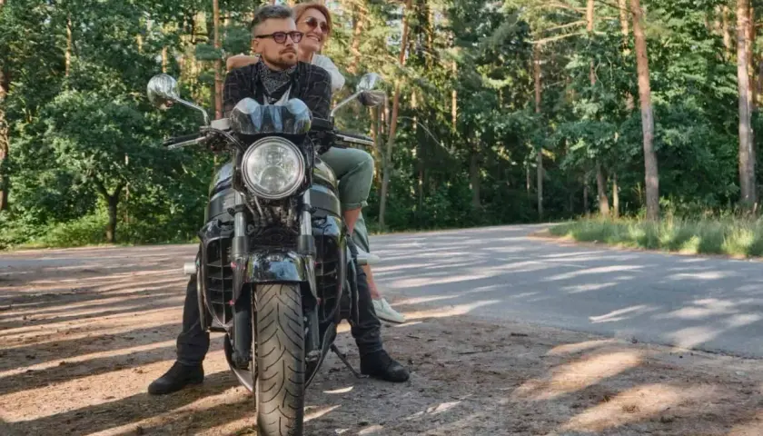 Para z uśmiechem na twarzy, podróżująca motocyklem po malowniczych Kaszubach.