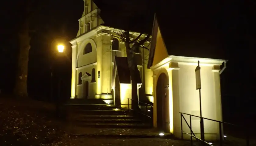 Nocne iluminacje kościołów w Wejherowie. Schody prowadzą do zabytkowych budowli, oświetlonych ciepłym światłem.