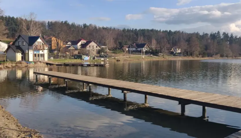 Drewniane pomosty nad jeziorem, domki letniskowe i las tworzą malowniczą stężyca trasę.