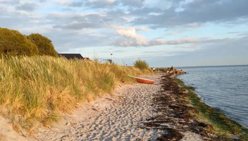 Piękna plaża w Kuźnicy, z łódką na piasku i trawami na wydmach. Idealne miejsce na relaks i podziwianie widoków. Kuźnica atrakcje to przede wszystkim spokój i bliskość natury.
