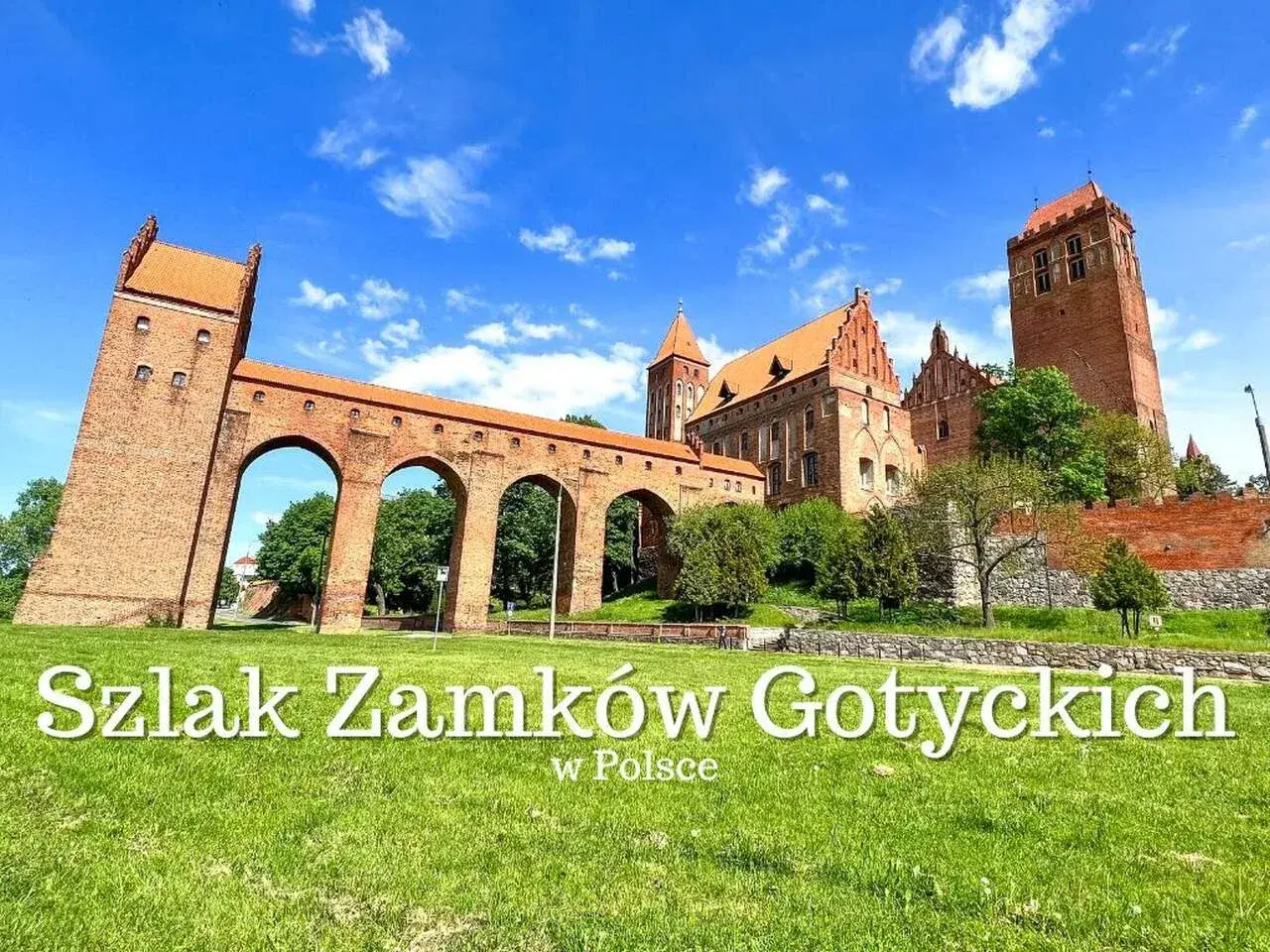Gotycki zamek z cegły, część szlaku zamków krzyżackich, z charakterystycznym łukowym mostem i wieżą.