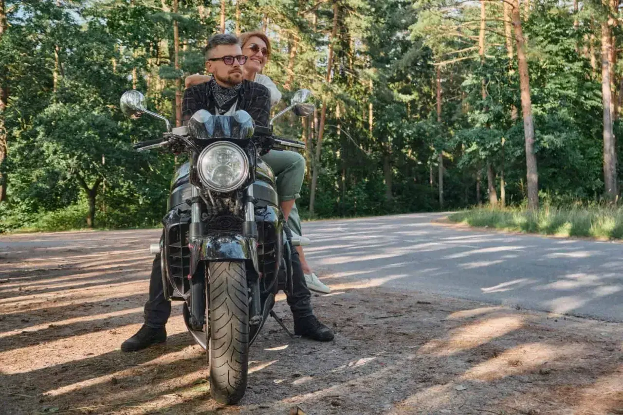 Para z uśmiechem na twarzy, podróżująca motocyklem po malowniczych Kaszubach.