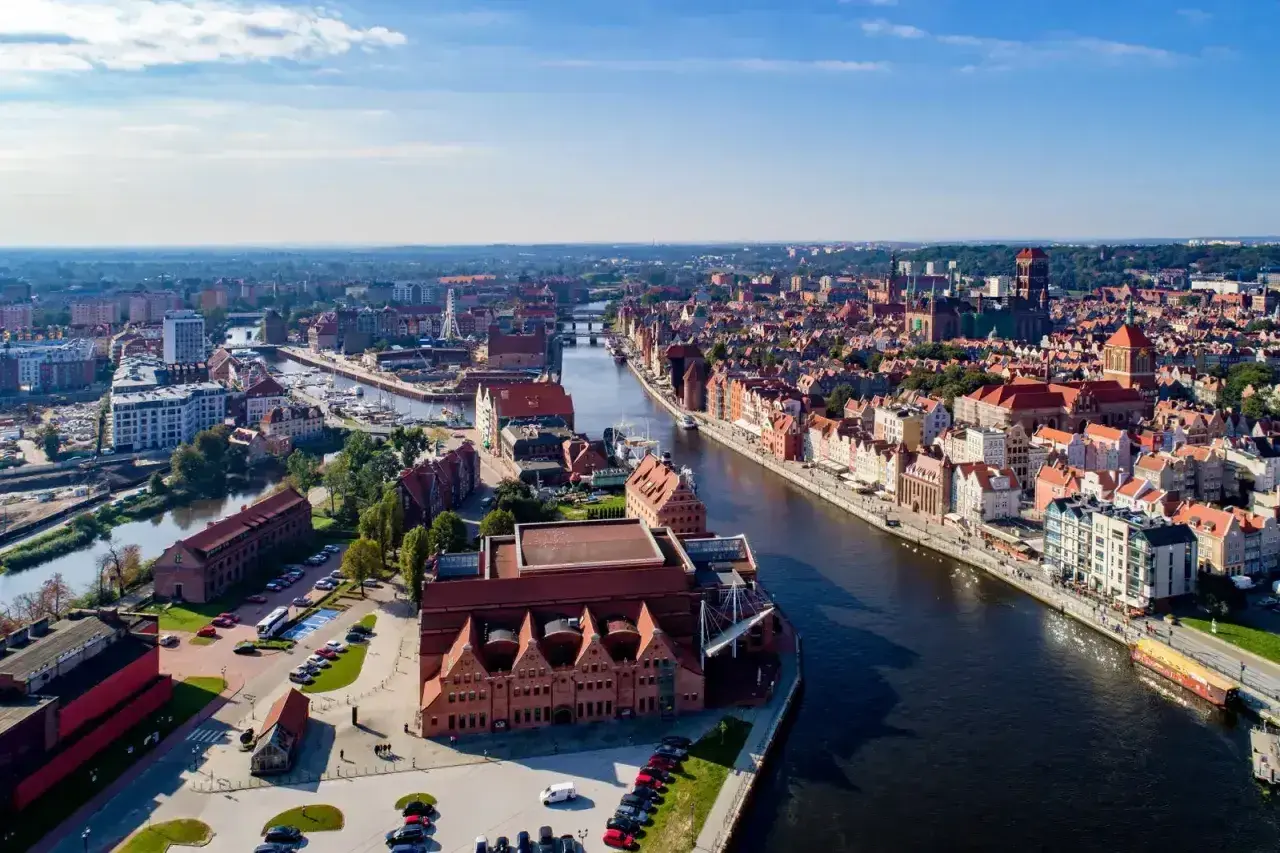 Gdańsk atrakcje: malowniczy widok na Motławę, Stare Miasto z charakterystyczną architekturą i nowoczesne budynki.