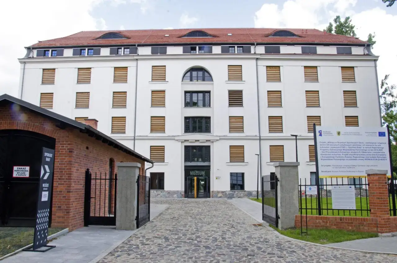 Biały spichlerz w Słupsku, dziś Muzeum Pomorza Środkowego, z ceglanym budynkiem obok.