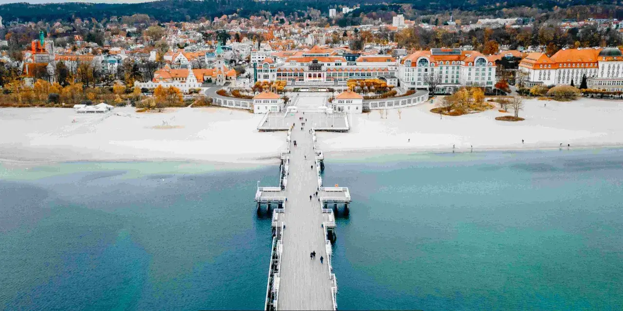 Sopot atrakcje: Molo spacerowe i plaża w Sopocie, z widokiem na zabytkowe budynki i morze.