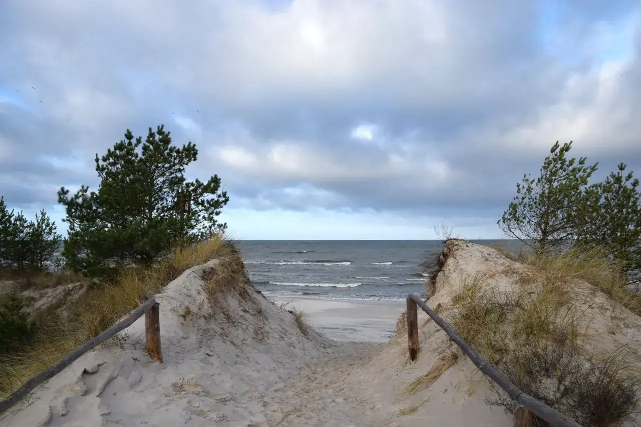 Ścieżka przez wydmy prowadzi do morza. Choczewo atrakcje to piękne plaże i spokój natury.