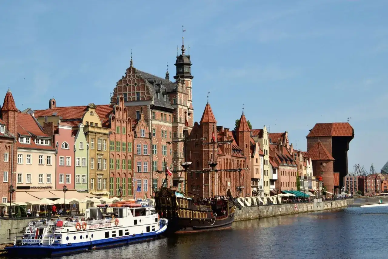 Gdańsk atrakcje: zabytkowa kamieniczki, żaglowiec i statki wycieczkowe przy Motławie.